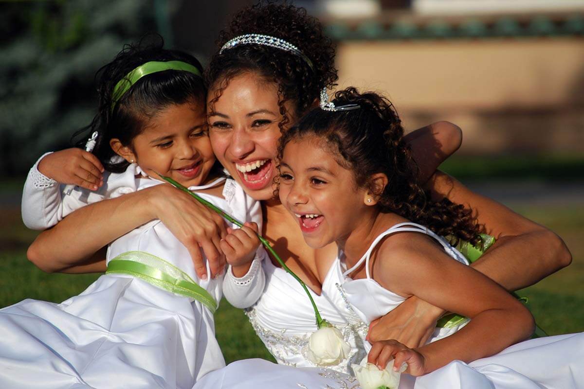 smiling bride hugging two young girls